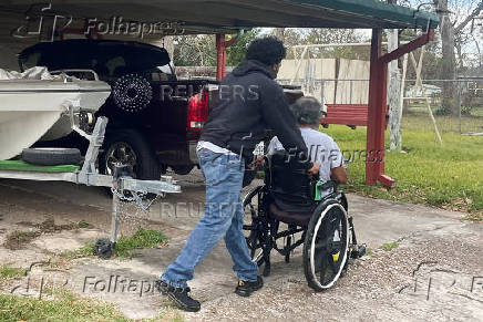 Abdur Rahim Jabbar, half-brother of the Texas truck attack accused, wheels their dad in front of their house in Beaumont