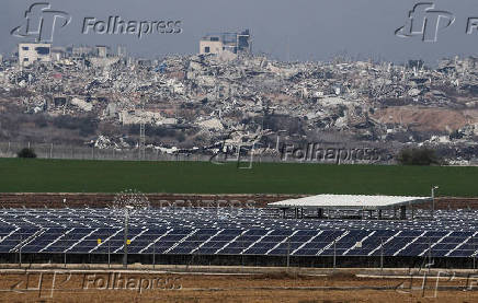 Solar panels stand on the Israeli side as buildings lie in ruin in Jabaliya in the Gaza Strip, amid the ongoing conflict between Israel and Hamas, as seen from southern Israel