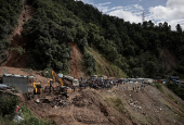 Rescue personnel work to retrieve the bodies of victims from a landslide triggered by heavy rainfall at the Tribhuwan Highway in Dhading