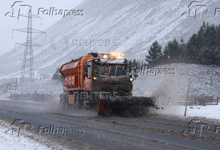 A snow plough operates on the A9 at the Drumochter pass, Scotland