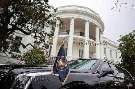 A car with flags baring the presidential seal is seen at the White House in Washington