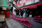 The broken sails of the landmark red windmill atop the Moulin Rouge, Paris' most famous cabaret club, are taken away after they fell off during the night in Paris