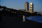 A tourist enjoys a sunny spring day in front of the Mediterranean Sea at the Barceloneta beach in Barcelona