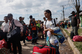 Venezuelans queue to enter a shelter after leaving Venezuela, in Pacaraima