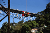 Guatemalan firefighter dressed as Santa Claus rappels down the Vacas Bridge to give toys to children, in Guatemala City