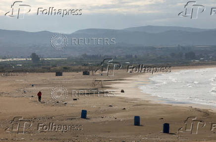 A man jogs on a beach in Tyre