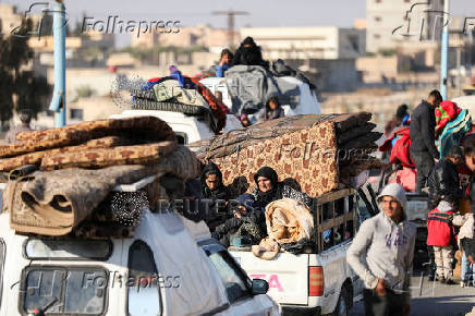 Displaced people who fled from Aleppo countryside, ride on vehicles with belongings in Tabqa