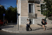 Tourists carry their luggage in the neighborhood of Koukaki, in Athens