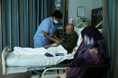 A medical staff assists Ahmad Fahess, a displaced man from the southern Lebanese town of Nabatieh with sarcoma cancer, at AUBMC in Beirut