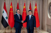 FILE PHOTO: Chinese President Xi Jinping shakes hands with Syria's President Bashar al-Assad in eastern Hangzhou city