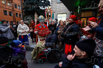 People dressed in traditional clothes sing carols for injured service members in Kyiv