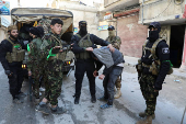 Fighters of Hayat Tahrir al-Sham (HTS) search for pro-Assad fighters and weapons in Homs