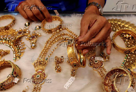 FILE PHOTO: A woman looks at a gold bangle inside a jewellery showroom at a market in Mumbai