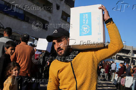 Palestinians receive aid following a ceasefire between Israel and Hamas, in Khan Younis in the southern Gaza Strip