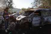 Palestinians assess the damage at the scene, after what they said was an attack by Israeli settlers on their village of Um Safa