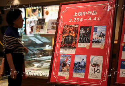 A woman looks at current movie posters including the Oscar's Best Picture winning movie 'Oppenheimer' at a movie theatre in Hiroshima