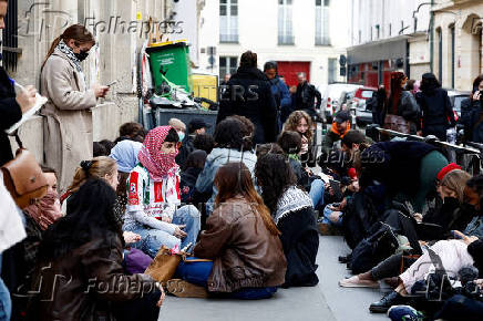 Masked youths take part in the occupation of a building in support of Palestinians in Gaza, in Paris