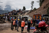 Rescue personnel work to retrieve the bodies of victims from a landslide triggered by heavy rainfall, in Dhading