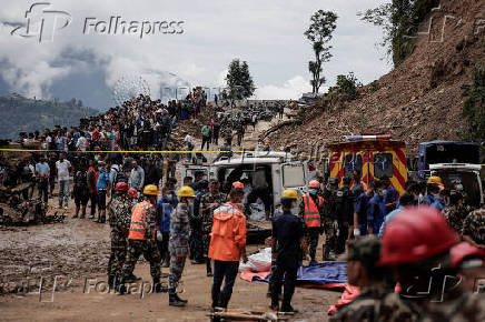 Rescue personnel work to retrieve the bodies of victims from a landslide triggered by heavy rainfall, in Dhading