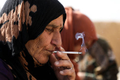 Tarfah Daaoud, a Kurdish Syrian woman smokes a cigarette at her home in Hasakah