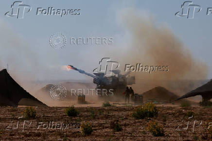 An Israeli military vehicle fires near the Israel-Gaza border, amid the ongoing conflict between Israel and the Palestinian Islamist group Hamas, in southern Israel