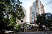 Casas com placas de venda-se perto de prdios de luxo, em So Paulo