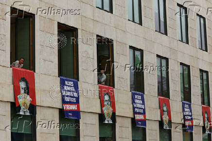 Far-right political party Chega expose banners on the facade of the Portuguese parliament against the wage reinstatement for politicians after the cuts imposed by the Troika, during the debate and vote of the 2025 budget bill on final reading, in Lisbon