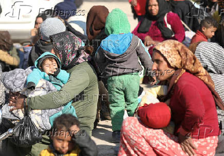 Displaced women who fled Aleppo countryside, sit with their children in Tabqa,