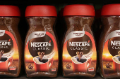 Nescaffe Classic are displayed on a shelf in a supermarket