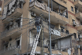 A man repairs electricity cables in Beirut's southern suburbs