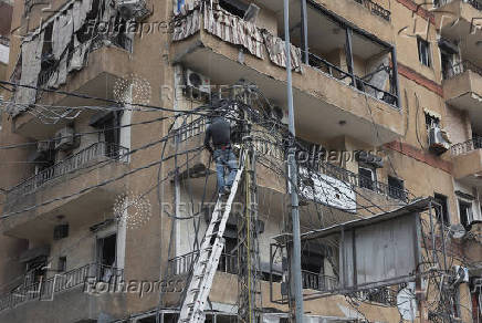 A man repairs electricity cables in Beirut's southern suburbs