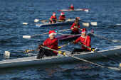 People in Santa Claus costumes row off the seafront of Thessaloniki