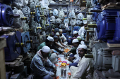 Muslims pray before they eat their Iftar (breaking of fast) meal at a shop that sells electric motors, during the fasting month of Ramadan in the old quarters of Delhi