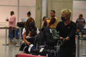 Turistas e funcionrios do Aeroporto do Galeo usam mscaras