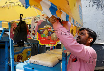 An ice cream vendor sets up his cart on a hot summer day in New Delhi