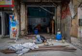 A man prays outside his shop damaged in an Israeli strike, after the ceasefire between Israel and Hezbollah, in Tyre