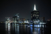 A boat sails near the Civic Centre Towers at night in Lagos