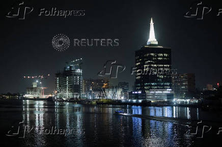 A boat sails near the Civic Centre Towers at night in Lagos