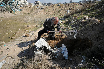 Palestinians search for bodies and graves of loved ones following a ceasefire, in Gaza City