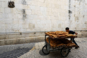 A Palestinian boy pushes a trolley of bread through a street in Jerusalem
