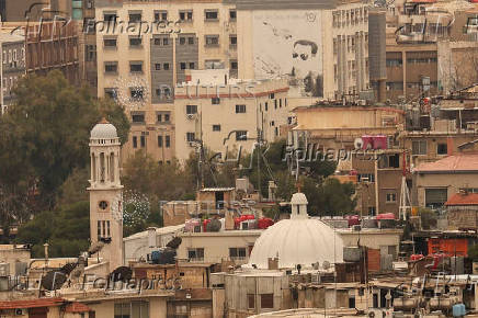 Syria's Bashar al-Assad's picture sits on a wall after he was ousted, in Damascus