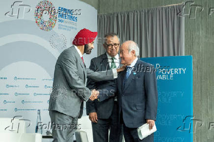 WBG President Ajay Banga shakes hands with Japanese Finance Minister Shun'ichi Suzuki during IMF meetings