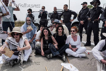 Israeli police stand by as protestors block a road during a demonstration by Israeli and American Rabbis while they gather to symbolically bring food to Gaza, near Erez crossing