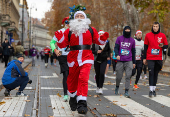 Runners wearing Santa Claus-themed outfits take part in the 