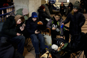 People take shelter inside a metro station during a Russian military strike, in Kyiv