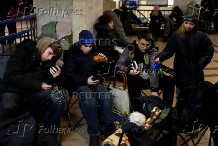 People take shelter inside a metro station during a Russian military strike, in Kyiv