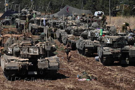 Israeli army soldiers and tanks gather in northern Israel