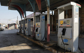 A vehicle stands at a closed gas station in Aleppo