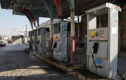 A vehicle stands at a closed gas station in Aleppo