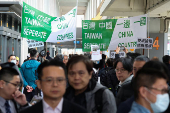 Protesters holding flags supporting Taiwan's independence stand outside the Songshan Airport while Shanghai Vice Mayor Hua Yuan arrives for the annual city forum in Taipei